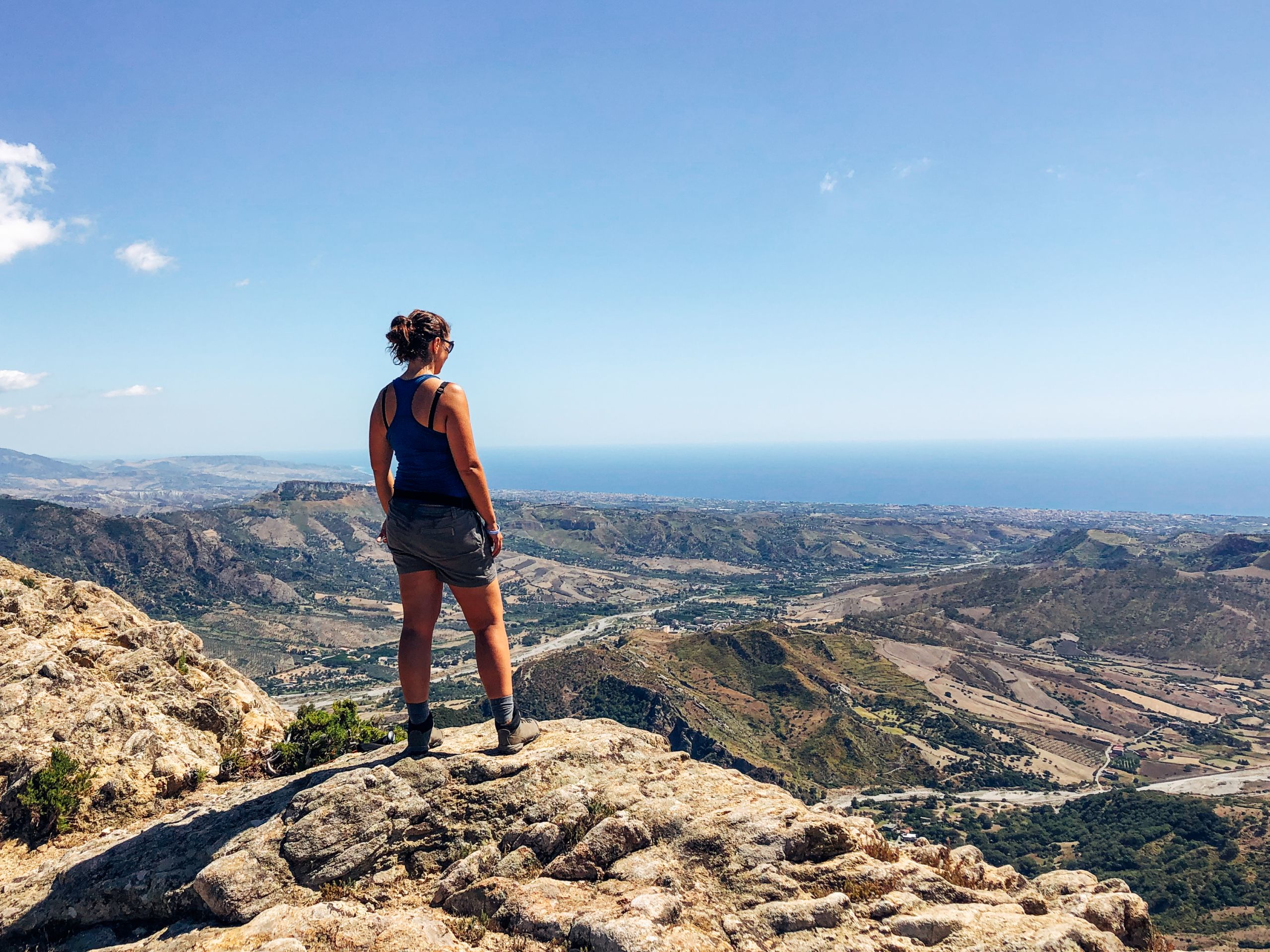 Persona su una grande roccia osserva l'orizzonte, trekking in Calabria indipendente Girolibero
